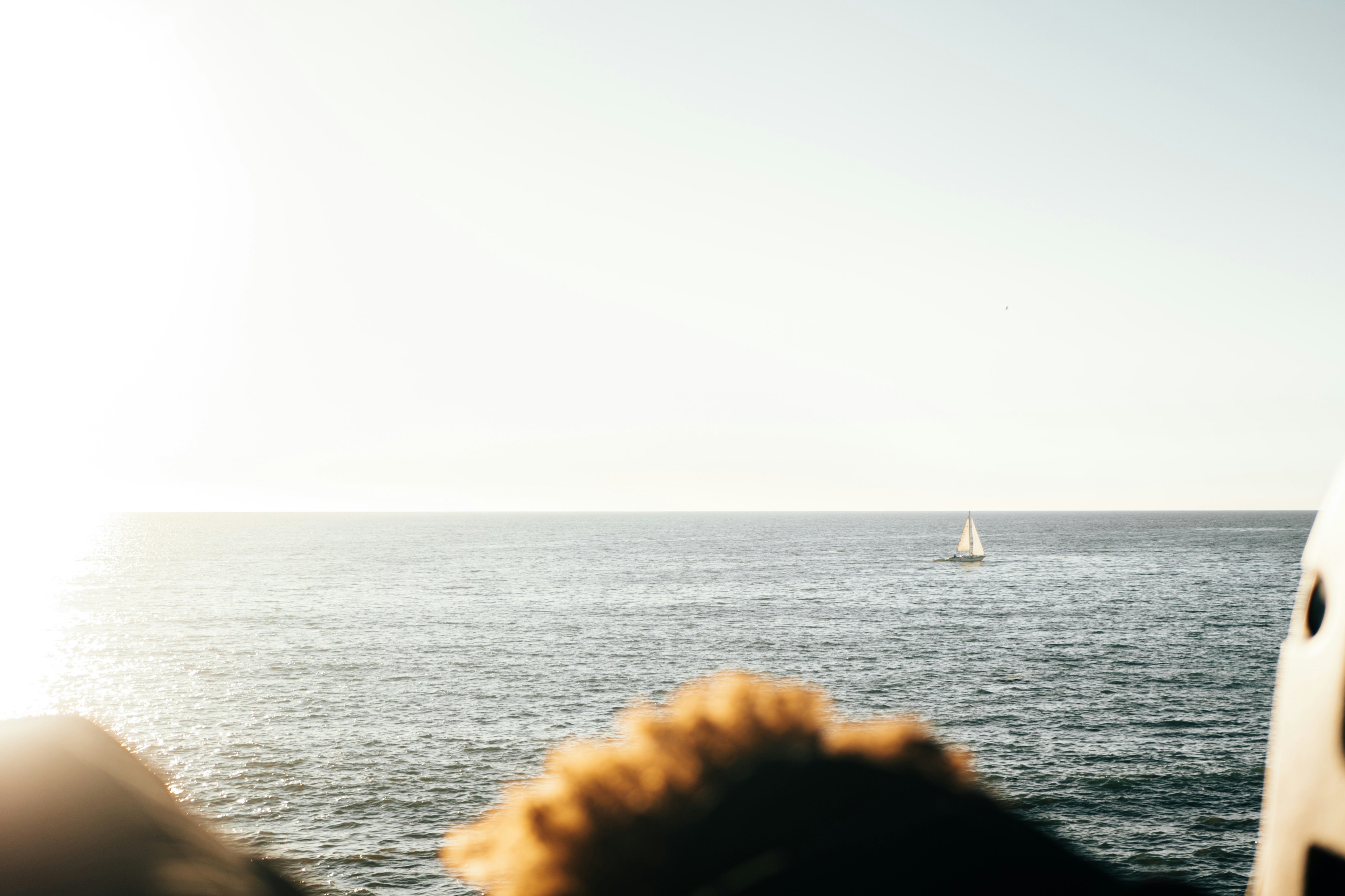 white sail boat on sea during daytime